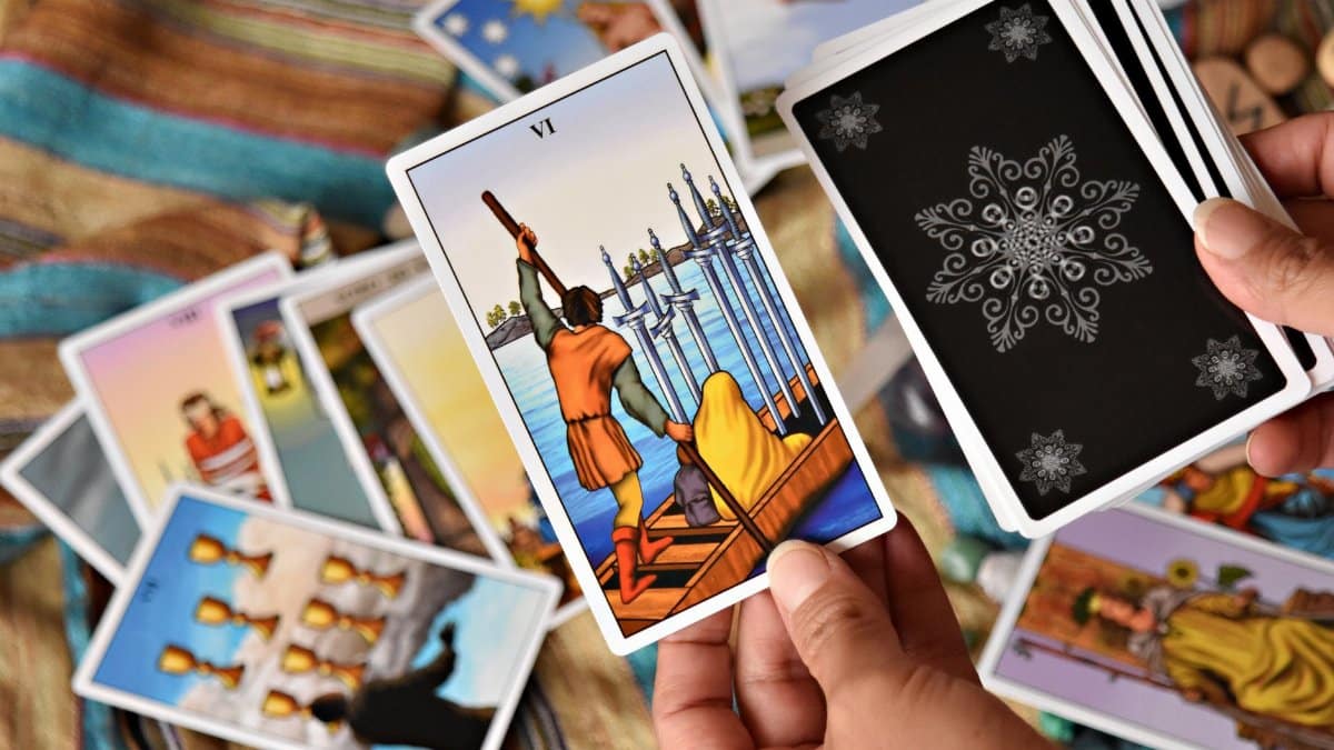 Close-up of hands holding colorful tarot cards, ideal for spiritual themes.