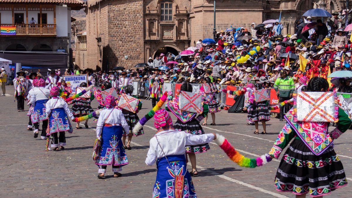Colorful traditional parade with dancers in Cusco, Peru, showcasing vibrant cultural attire.