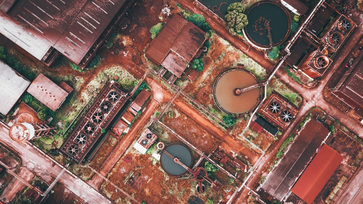 Drone view of contemporary industrial city district with manufacture constructions and factory warehouses