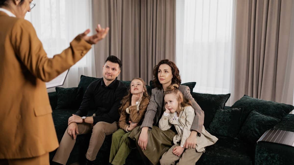 A family meeting with a real estate agent in a cozy living room, discussing home buying options.