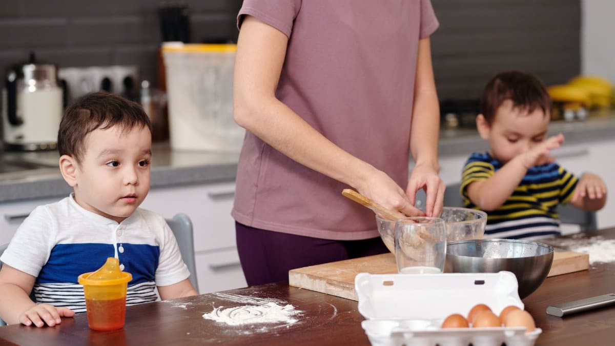 A mother and her young sons baking together, preparing dough and enjoying family time.