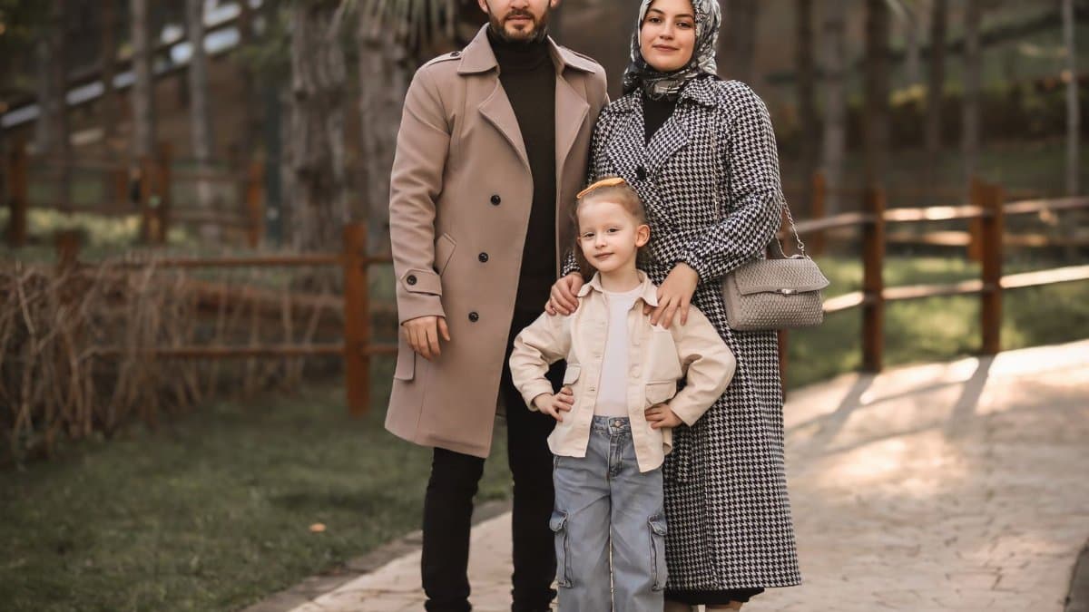 Happy family posing in an autumn park, showcasing fashion and unity.