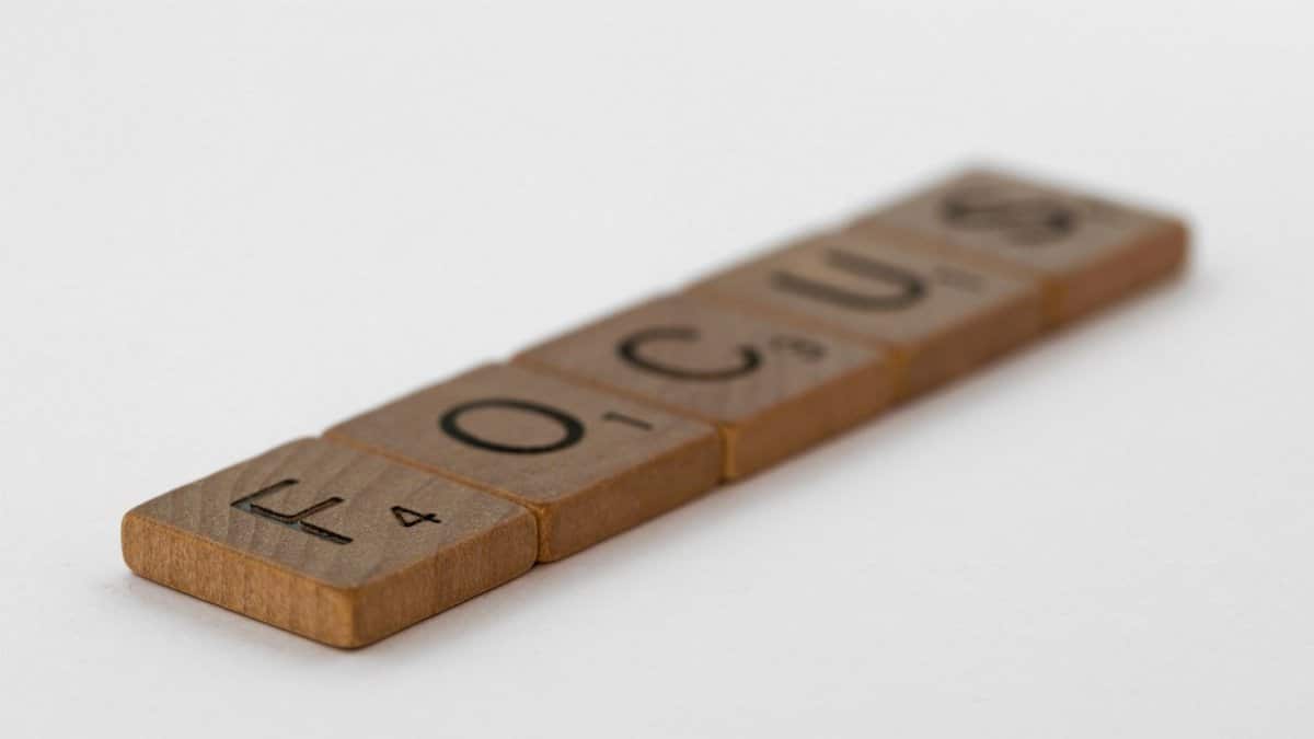Close-up of wooden tiles spelling 'focus', emphasizing clarity and concentration.