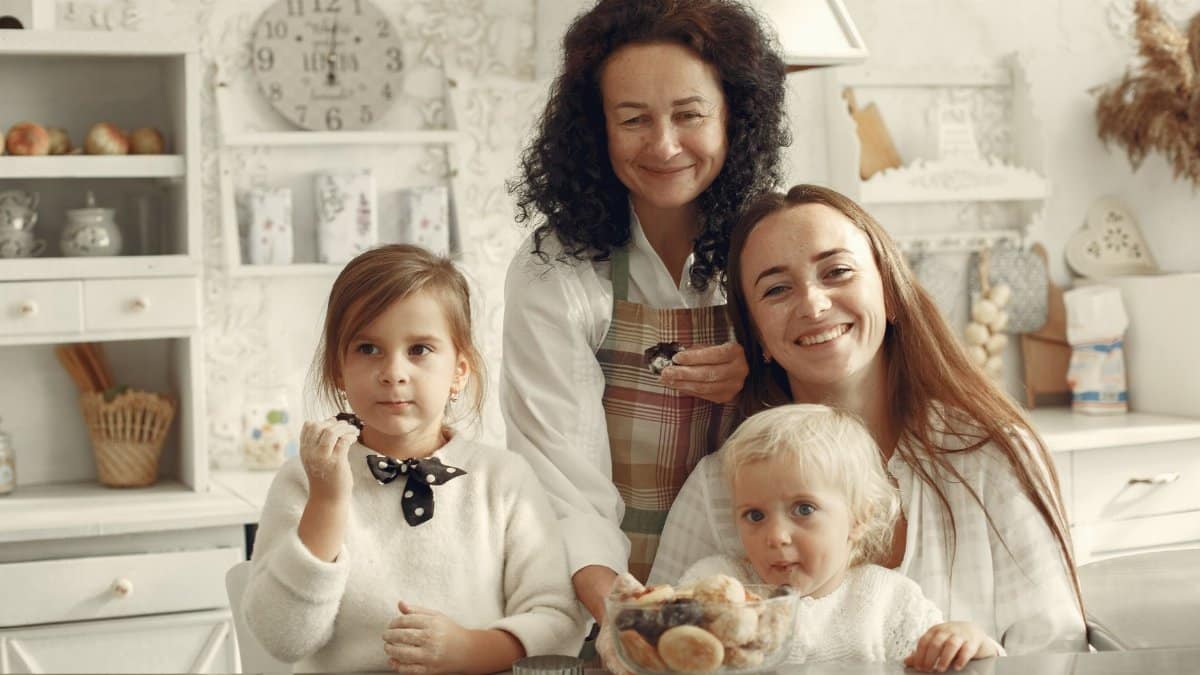 Happy family of three generations baking and smiling in a cozy kitchen.