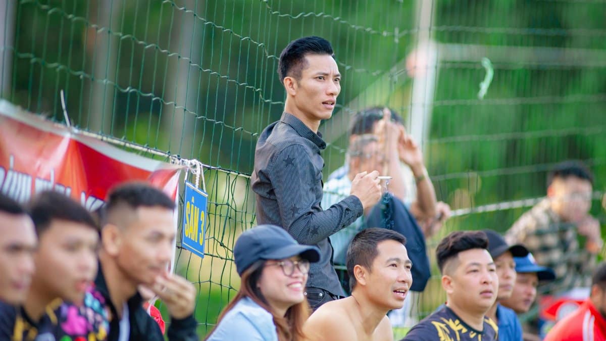 A lively group of spectators enjoying a soccer match in Hanoi, showcasing passion and community spirit.