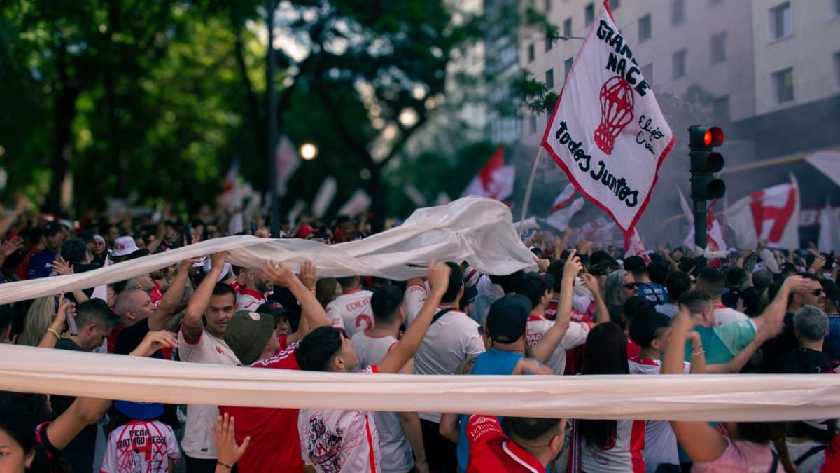 Crowd of cheering sports fans with flags during a street celebration in Buenos Aires, Argentina.