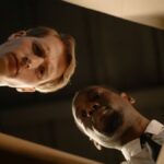 Two serious men peering into a box, showcasing a collaborative investigation scene.