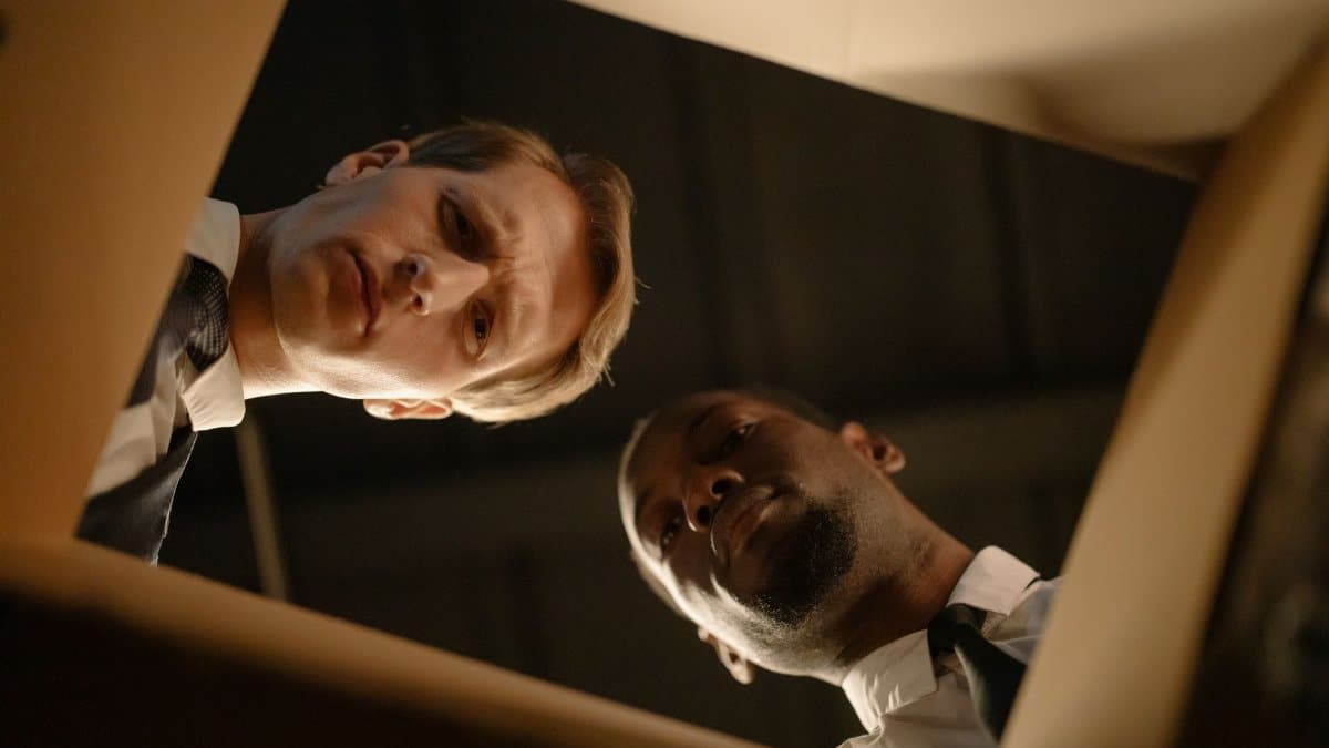 Two serious men peering into a box, showcasing a collaborative investigation scene.