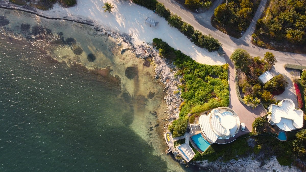 Stunning aerial photo of a luxurious coastal residence by the sea in the Cayman Islands.