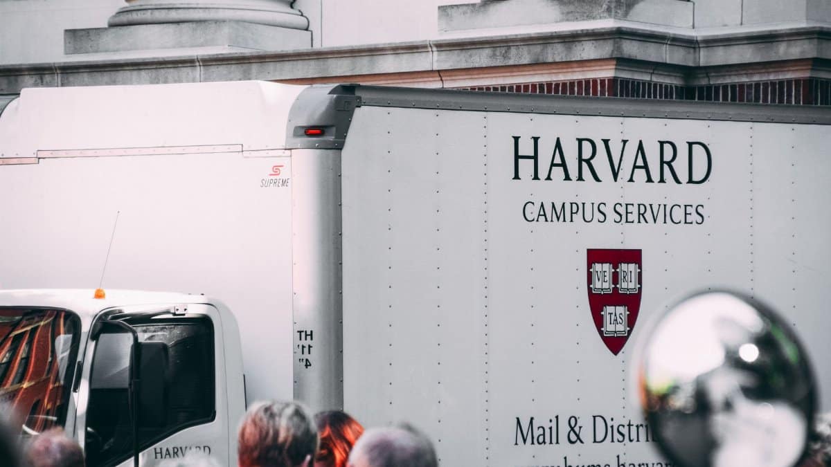 Harvard Campus Services truck in city street, showcasing delivery near university building.