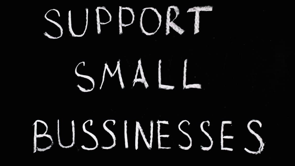 Inspirational chalkboard text 'Support Small Businesses' on black background.