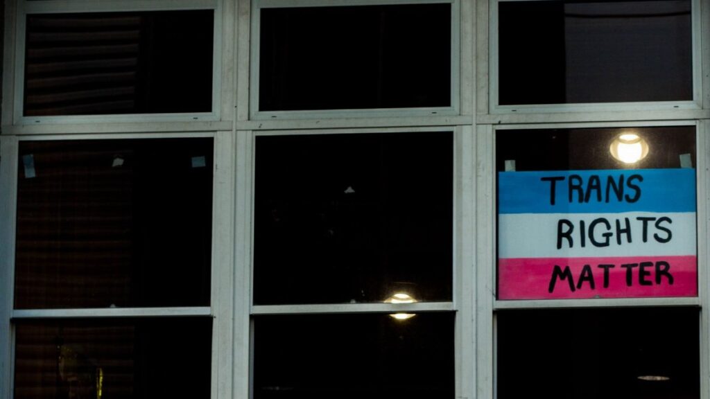 A photo of a Trans Rights Matter sign displayed in a window, emphasizing LGBTQ awareness.