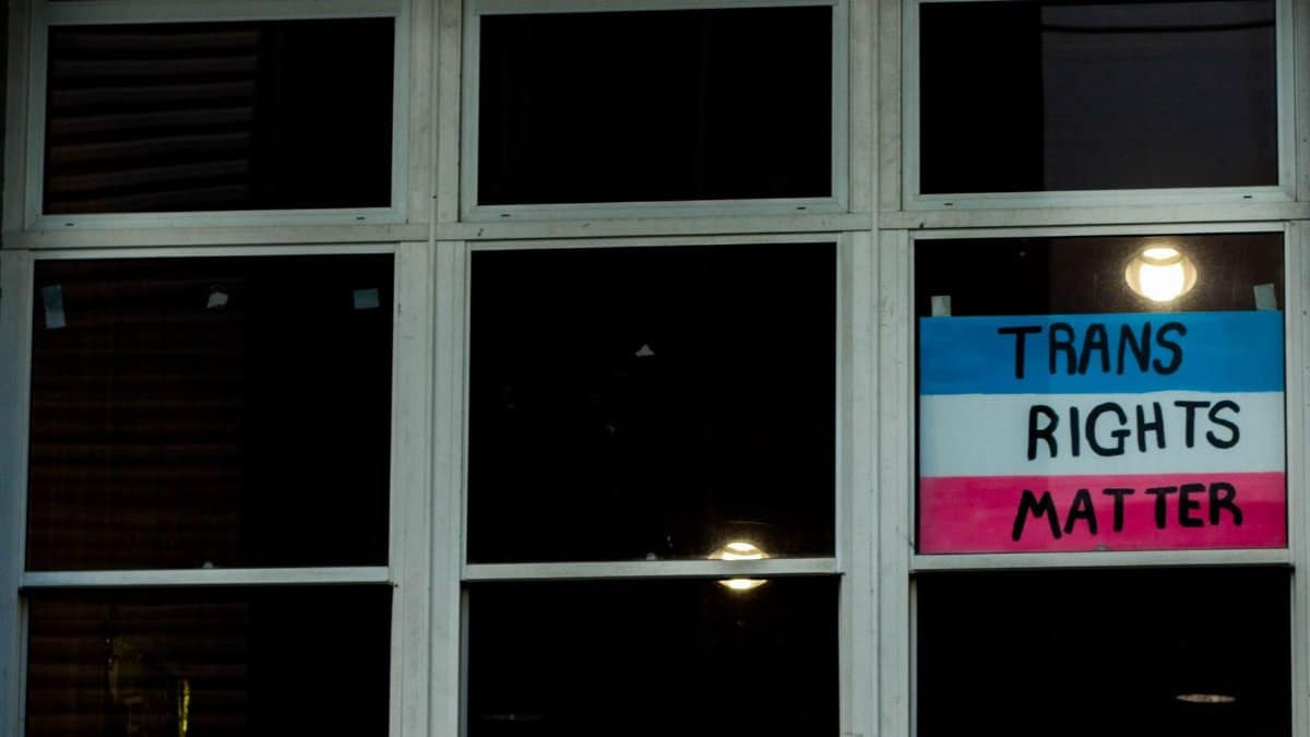A photo of a Trans Rights Matter sign displayed in a window, emphasizing LGBTQ awareness.