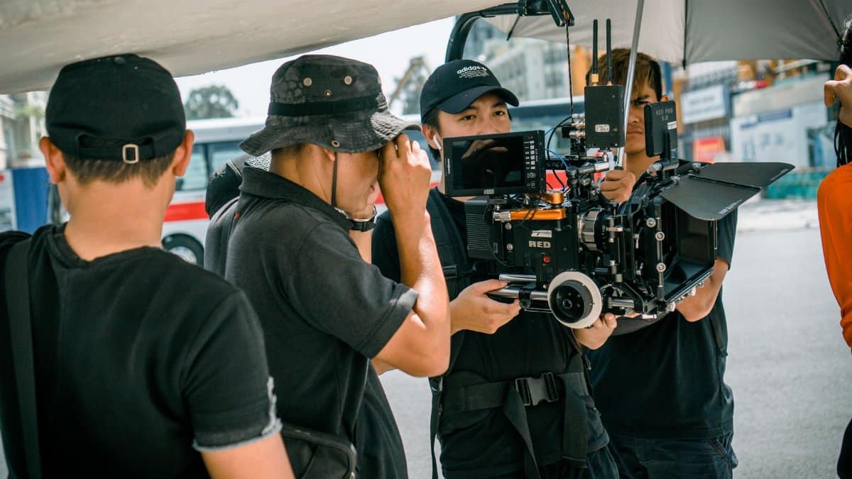 A group of filmmakers using professional camera equipment on an outdoor set.
