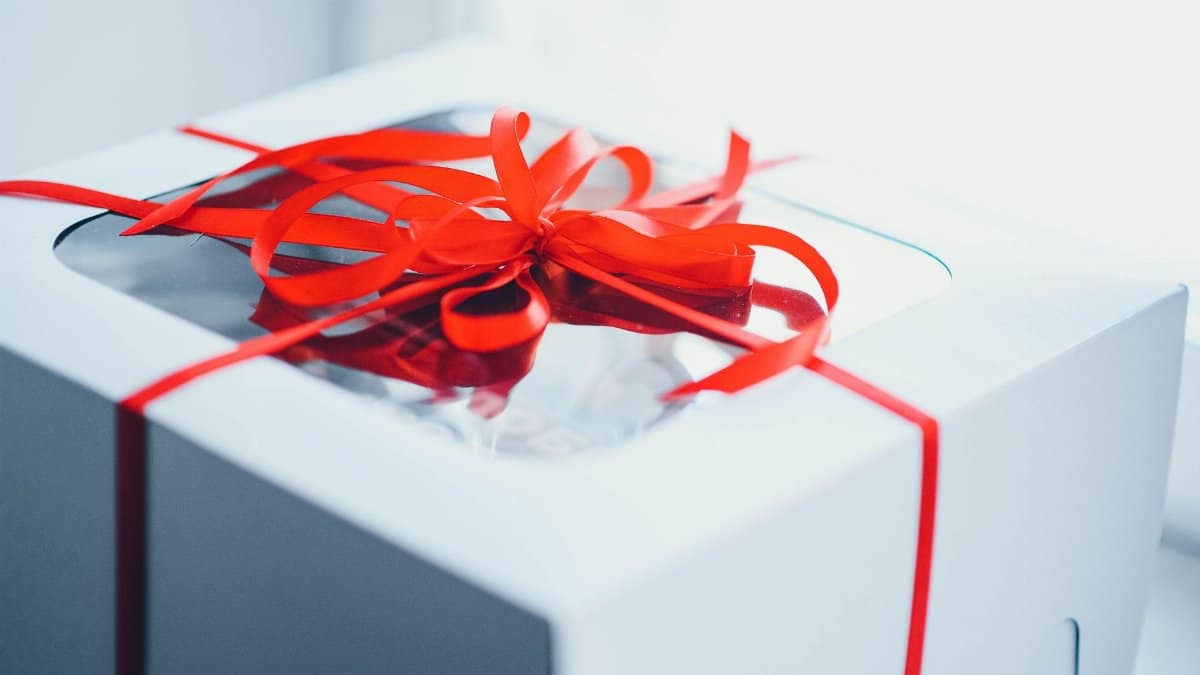 Close-up of a white gift box wrapped with a red ribbon, perfect for celebrations and special occasions.