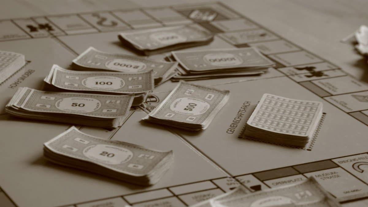 Close-up of board game with play money in sepia tone, focusing on strategic play.