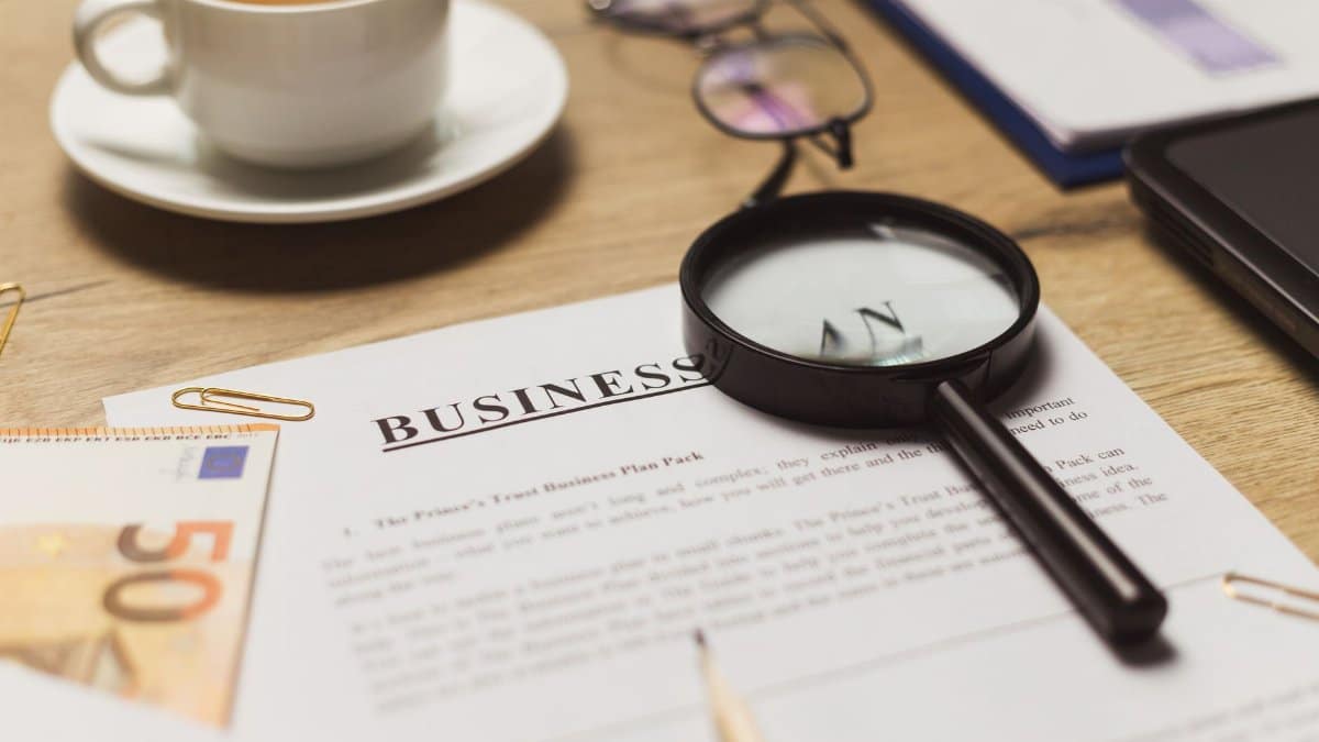 A business workspace setup featuring documents, coffee, and financial elements.