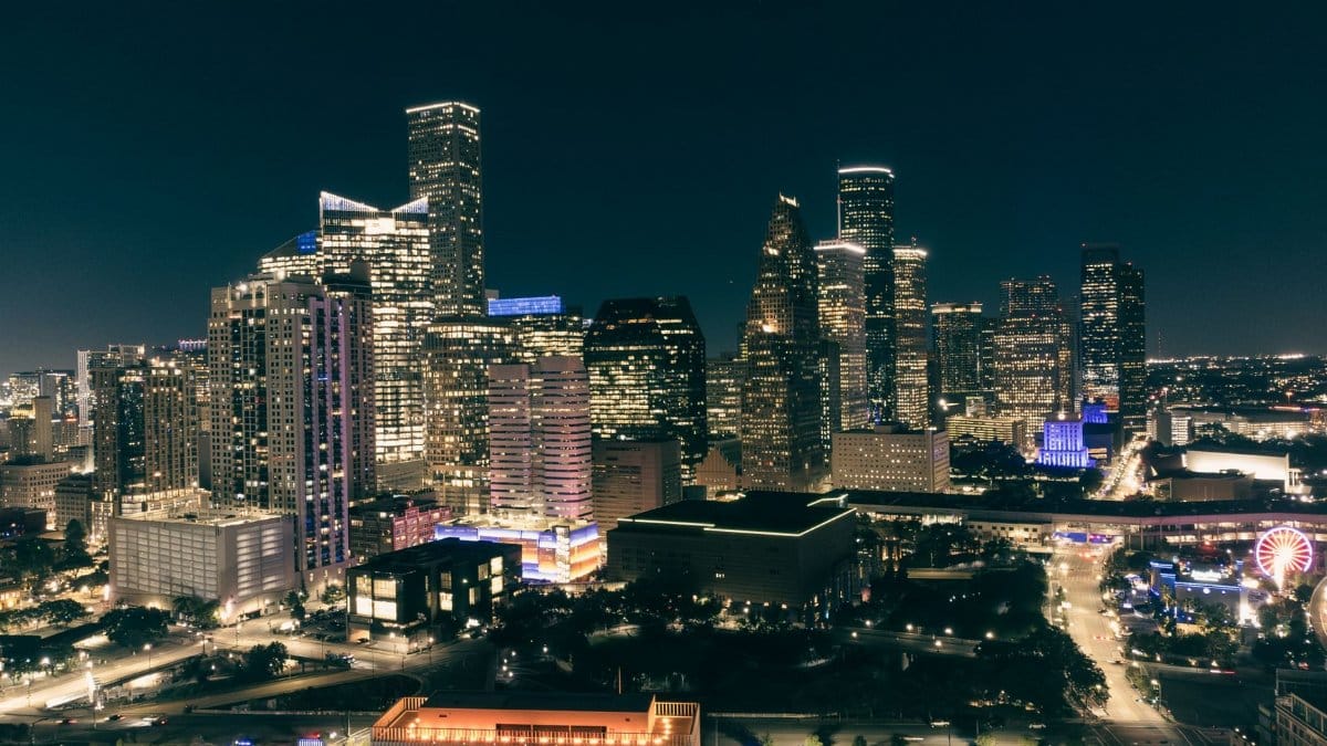 A breathtaking view of Houston's cityscape, illuminated at night with skyscrapers and bustling streets.