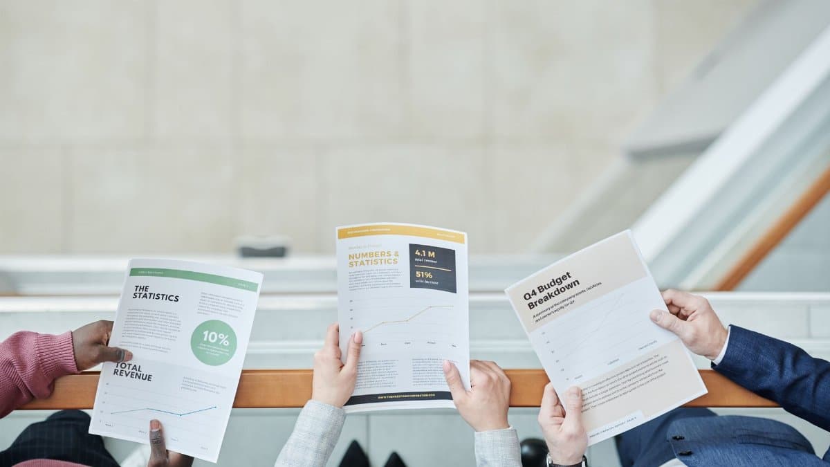 Group of business professionals analyzing financial documents in an office setting.