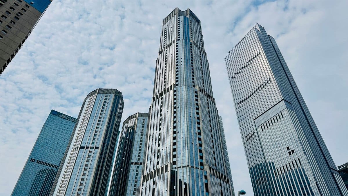 Tall modern skyscrapers of Tianjin under a partly cloudy sky, showcasing urban architecture.