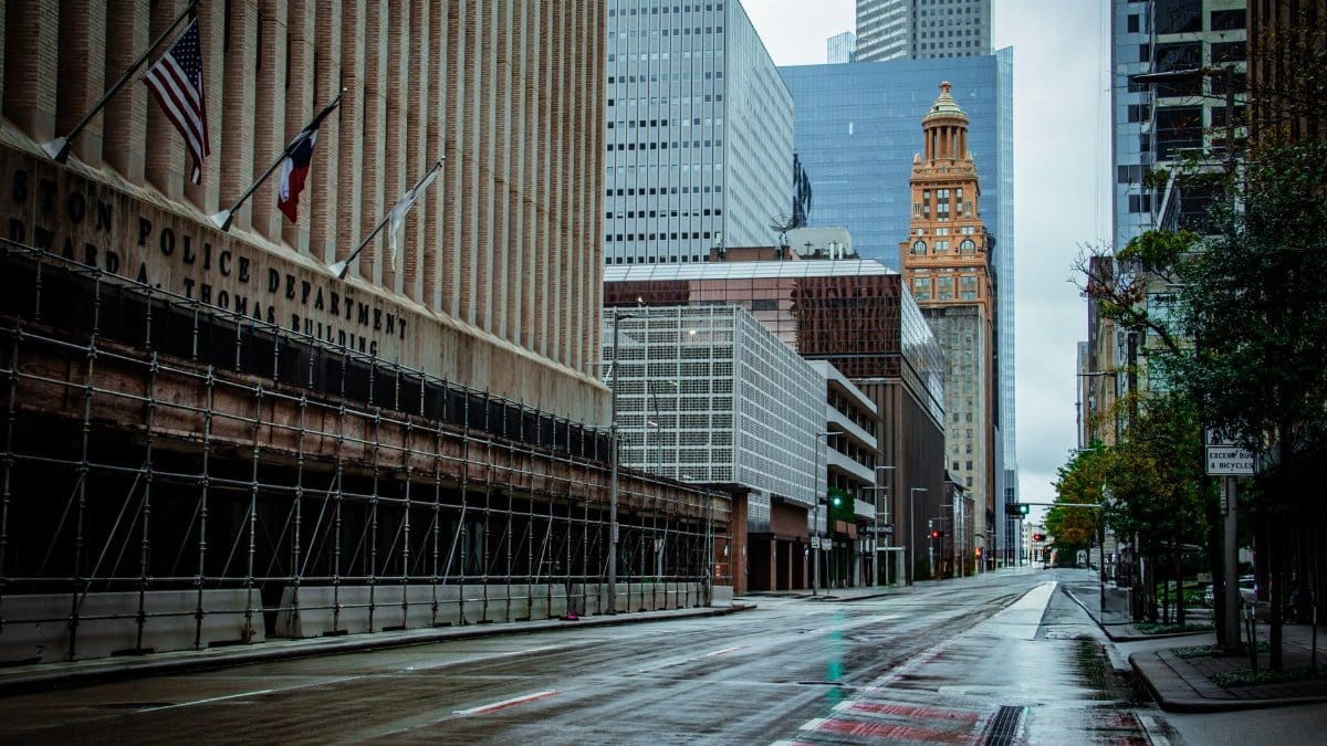 A rainy day view of Houston's downtown architecture featuring modern and historical buildings, empty street.