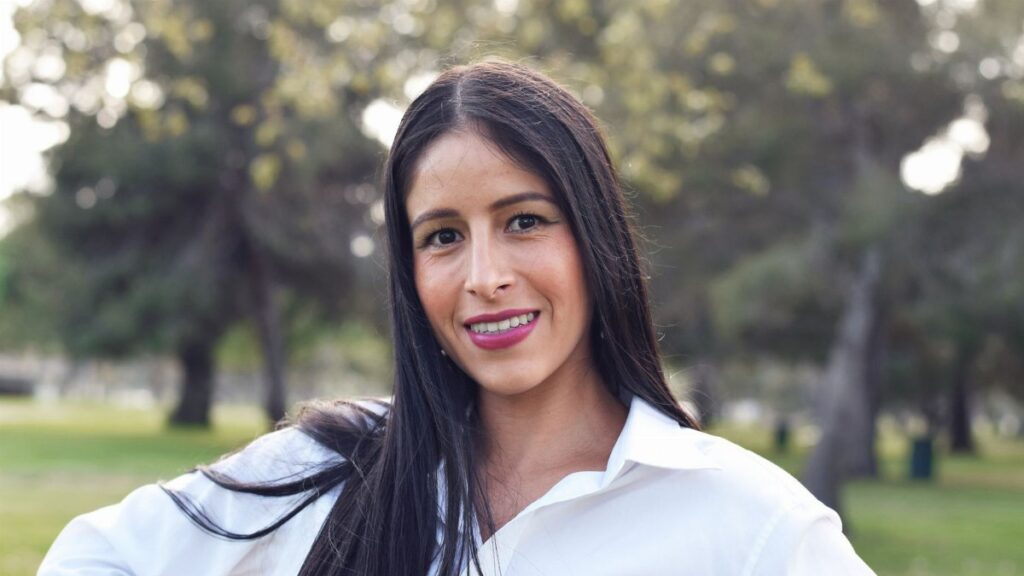Portrait of a young woman smiling outdoors in Long Beach park.
