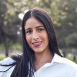 Portrait of a young woman smiling outdoors in Long Beach park.