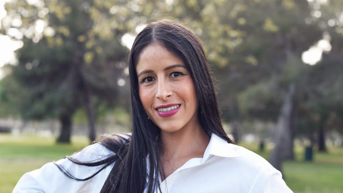 Portrait of a young woman smiling outdoors in Long Beach park.