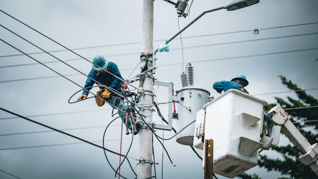 Electricians in San José, Costa Rica, repairing power lines from a cherry picker.