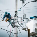 Electricians in San José, Costa Rica, repairing power lines from a cherry picker.
