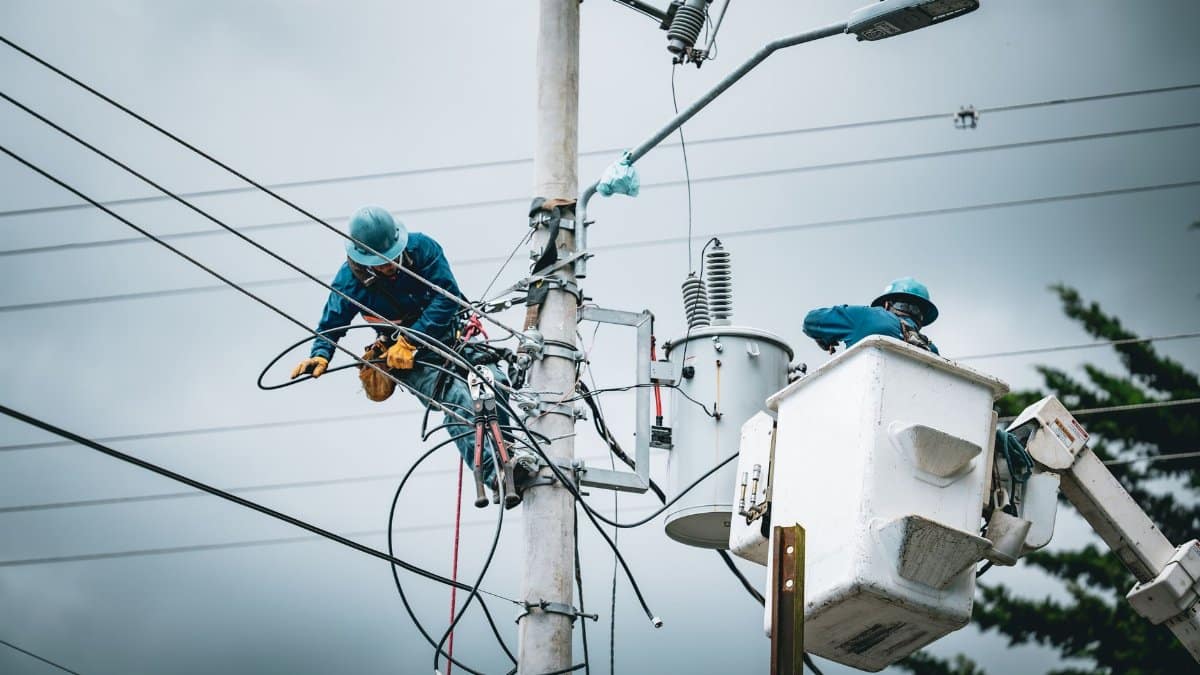 Electricians in San José, Costa Rica, repairing power lines from a cherry picker.
