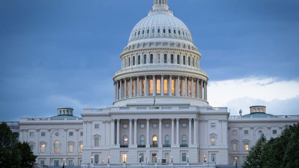 The iconic United States Capitol Building illuminated against a twilight sky.