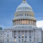 The iconic United States Capitol Building illuminated against a twilight sky.