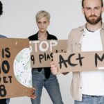 Activists hold cardboard signs advocating for environmental protection and climate action.