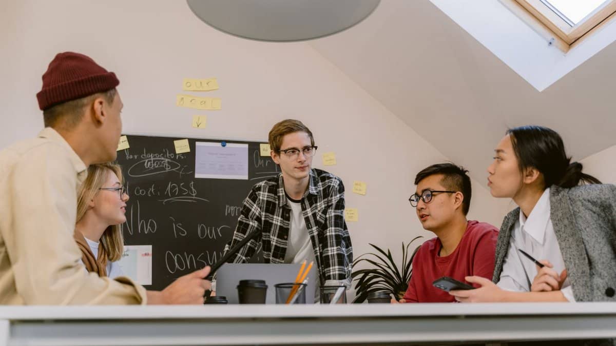 A diverse group of adults collaborating on a project in an office with a focus on creative brainstorming.