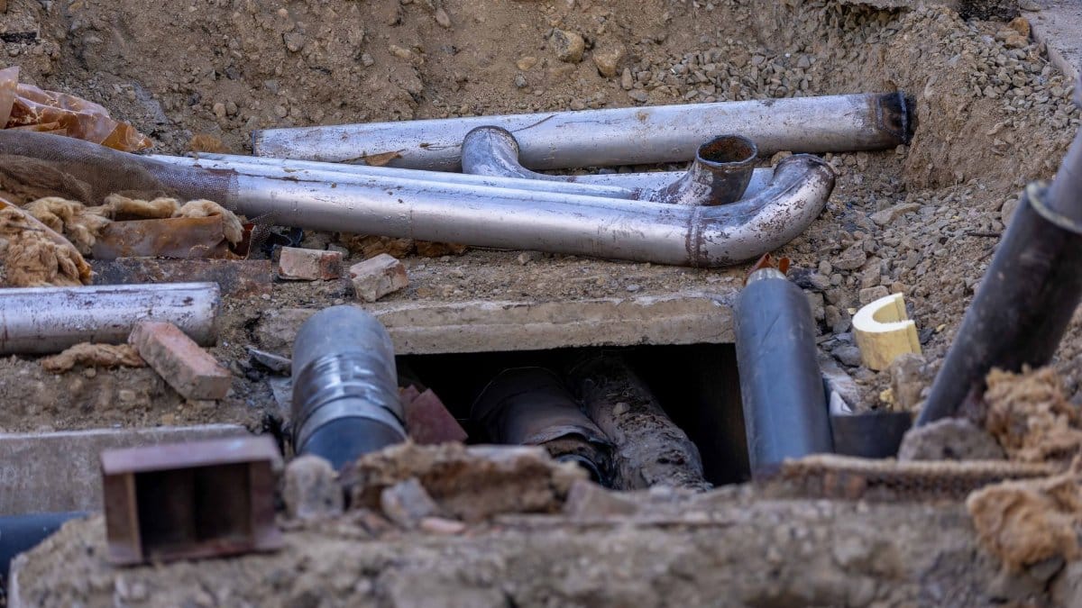 Close-up of urban pipe installation at a construction site, showing various pipes and materials.