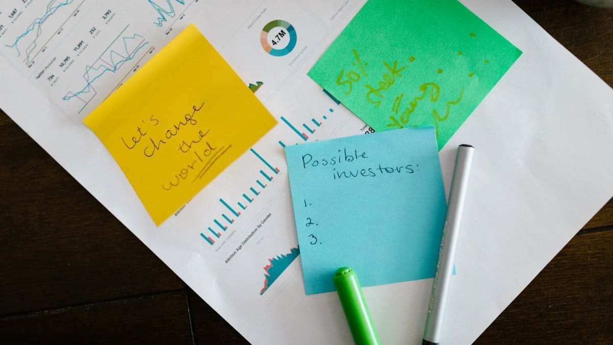Startup brainstorming with charts, colorful sticky notes, and planning strategies for success.