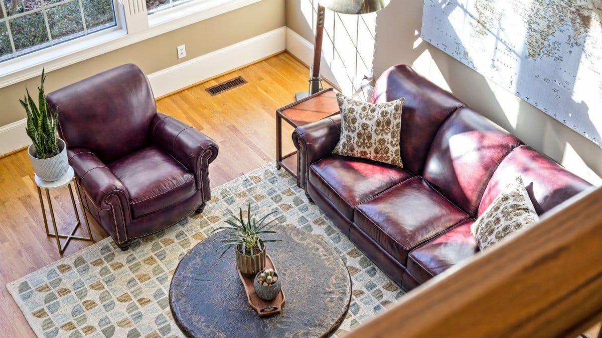 Bright living room with leather furniture, wooden flooring, and modern decor.