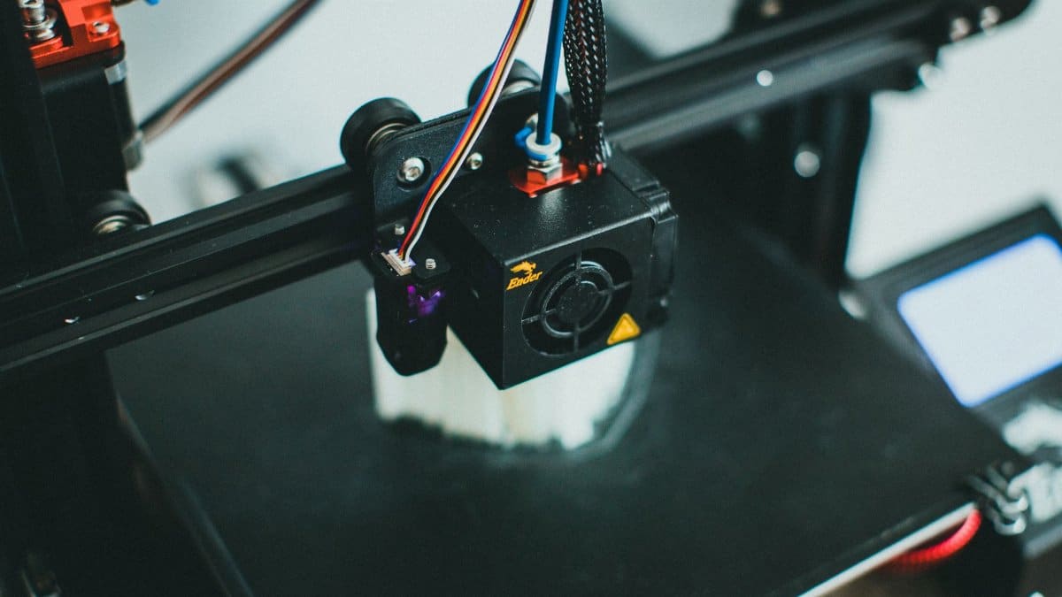 Detailed shot of a 3D printer creating an object, focusing on the cooling fan and print head.