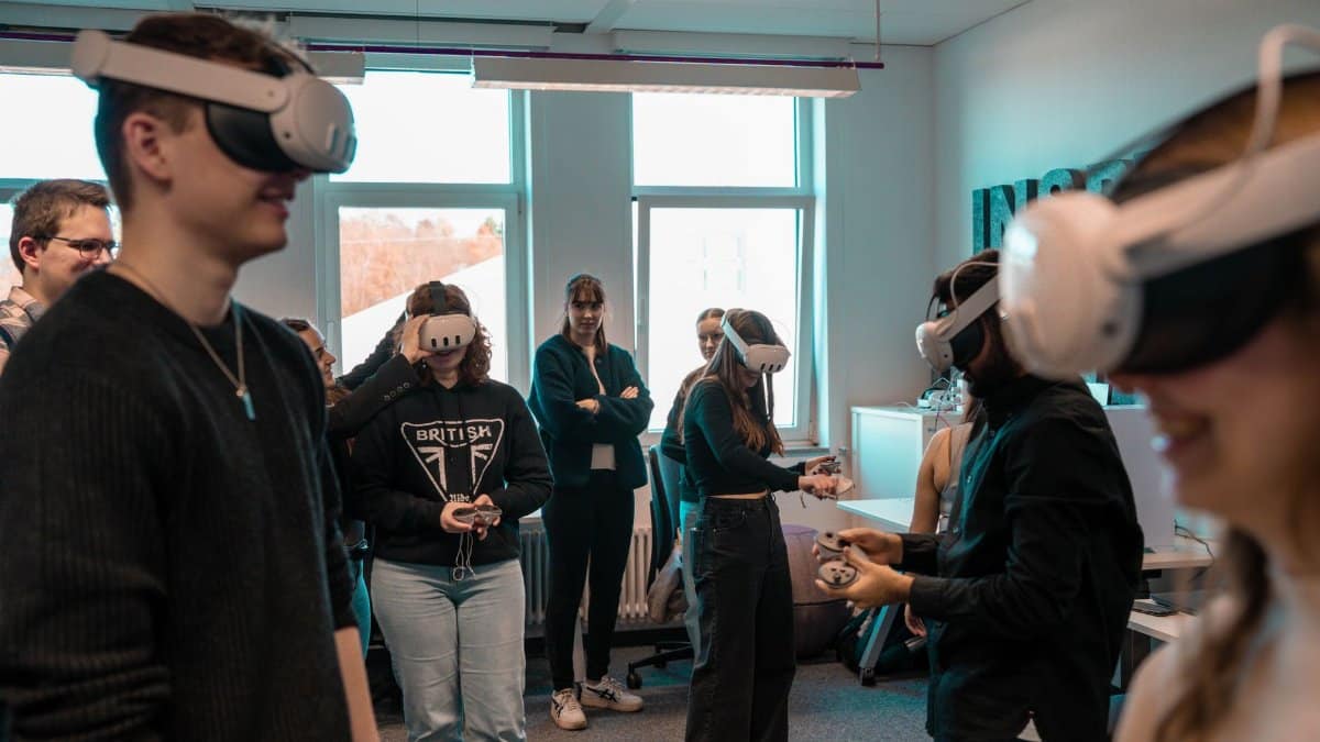 A group of diverse adults using VR headsets in an office setting.