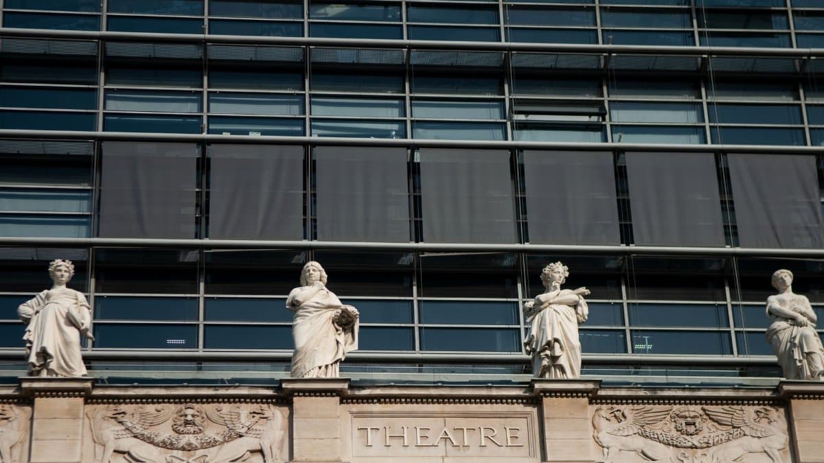 Low-angle shot of a theater facade in Lyon, France, adorned with classical sculptures