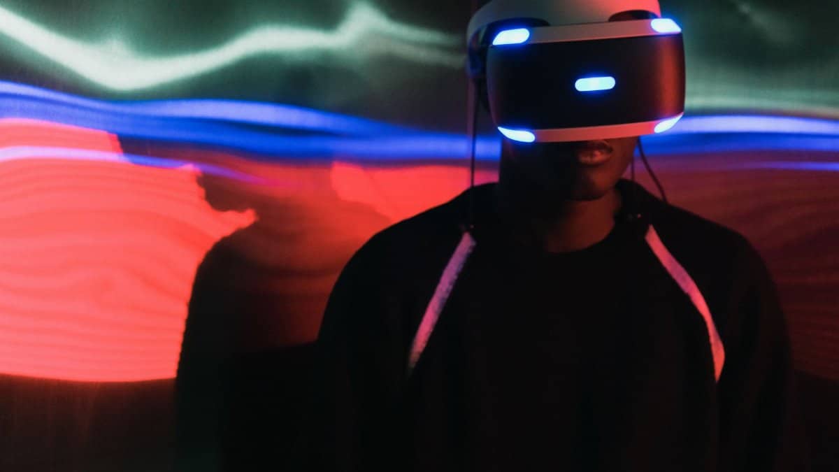 Person wearing a virtual reality headset with vibrant light trails in the background.