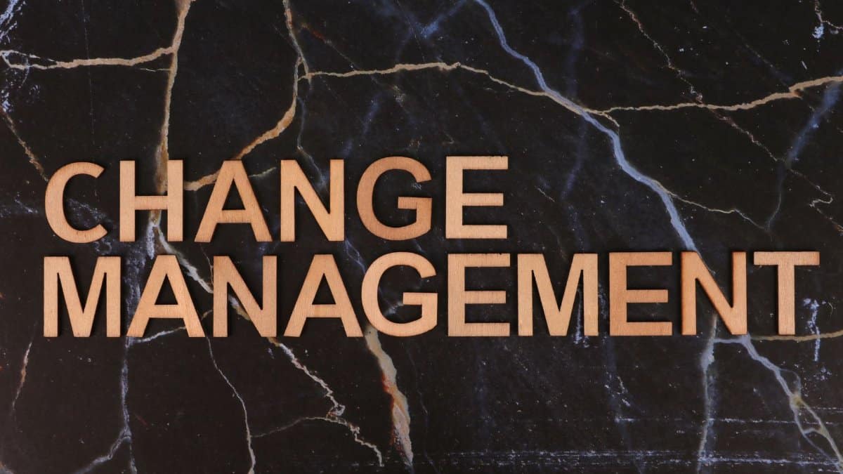 Wooden letters spelling 'Change Management' on a dark marble surface, emphasizing business change.