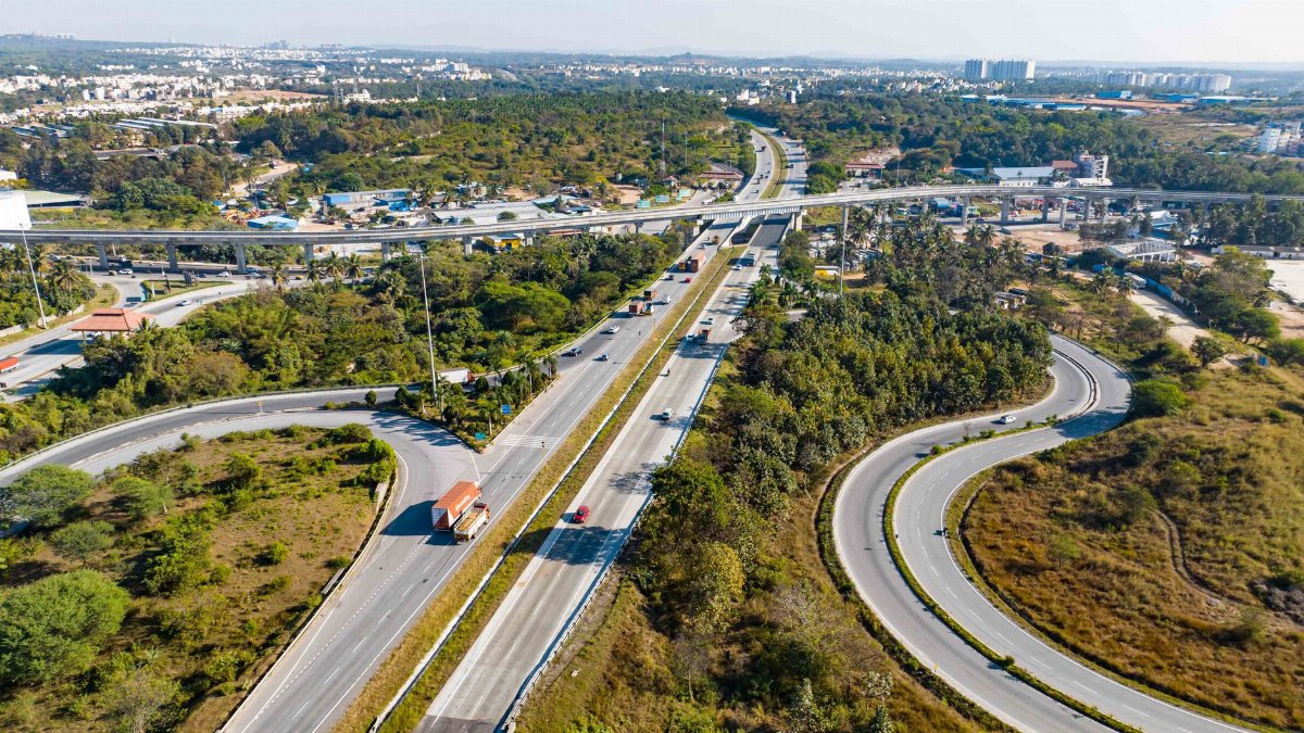 Stunning aerial view of a highway interchange surrounded by greenery in an urban area.