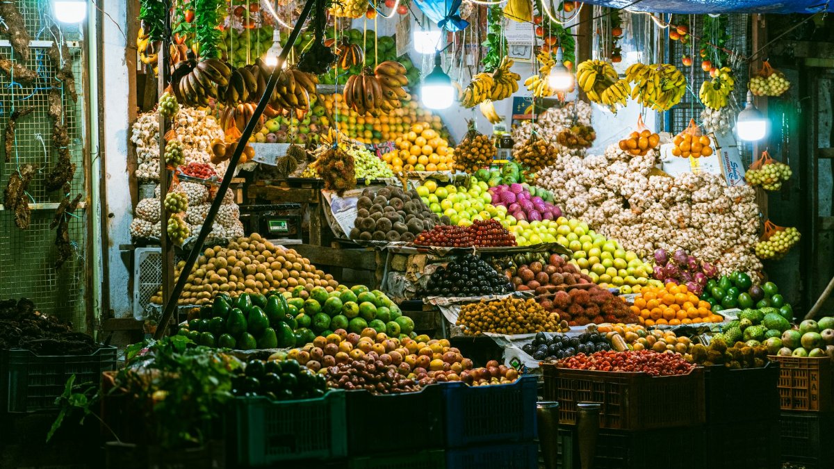 A bustling night market stall showcasing an array of colorful fruits and vegetables.