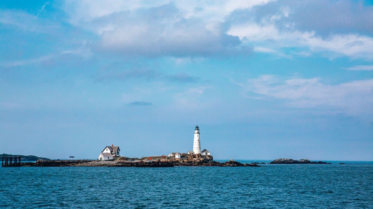 Scenic view of Boston Light lighthouse on rocky island in Boston Harbor, Massachusetts.