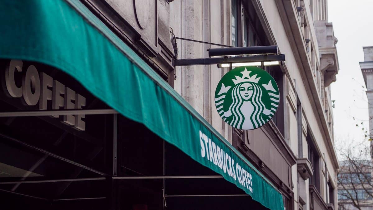 Exterior view of a Starbucks coffee shop in a city setting, featuring signage and awning.