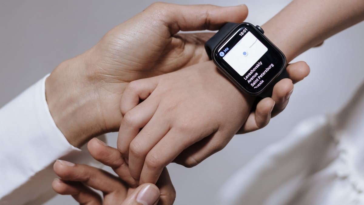 Close-up of a mother assisting her daughter with a smartwatch, emphasizing family care and technology.