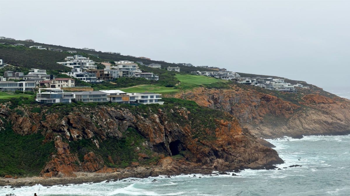 Stunning coastal view of a golf course and modern homes on cliffs in George, South Africa.