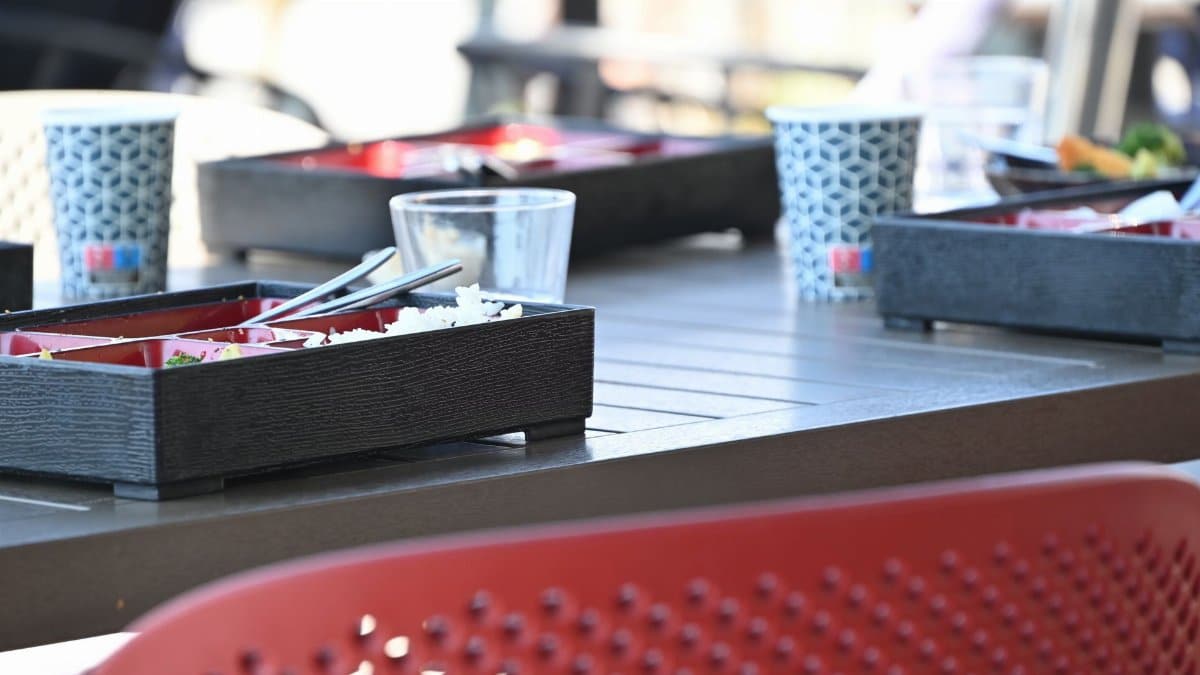 Modern outdoor dining setting with Japanese bento boxes on a table, perfect for casual meals.